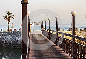 Ras Al Khaimah, UAE - 04.04.2022 - Wooden bridge leading to the beach at The Cove Rotana Resort. Holiday