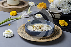 Ras malai in a traditional bowl on isolated background with flowers