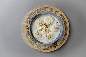 Ras malai in a traditional bowl on isolated background with flowers