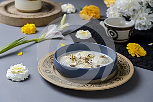 Ras malai in a traditional bowl on isolated background with flowers