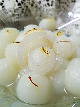 Rasagolla, a Bengali delicacy- served with saffron strands photo