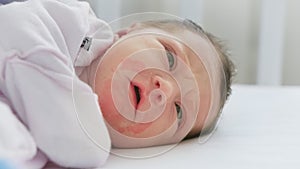 Rash and irritation around mouth of small child, skin problems Newborn girl with irritated skin on his face lying in bed