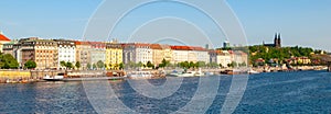 Rasin Embankment with boats on Vltava River on sunny summer day. Prague, Czech Republic