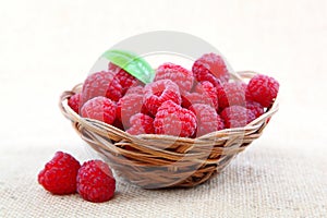 Raspberries in a basket on a homespun cloth