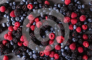 Raspberries, blackberries, blueberries a gray abstract background. Copyspace.