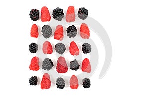 Raspberries and blackberries are laid out in a square on a white