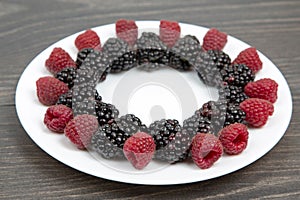 Raspberries and blackberries on a white plate. Vitamin and Diet Foo