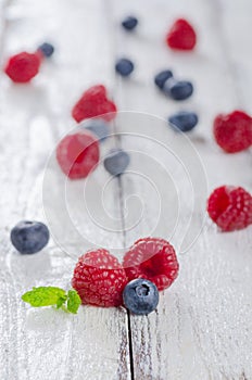 Raspberries and blueberries on white