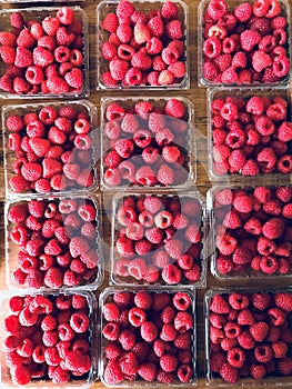 Raspberries at a farmers` market, a physical retail marketplace intended to sell foods directly by farmers to consumers.