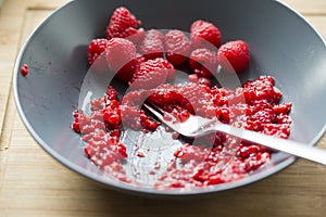 Raspberries smashing with fork
