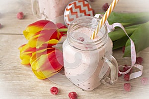Raspberries smoothie with colorful tulips and tape mesure