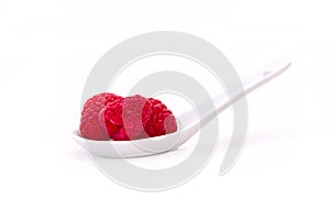 raspberries on spoon on white background