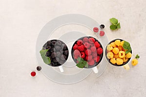 Raspberries of three colors are yellow, red and black, top view