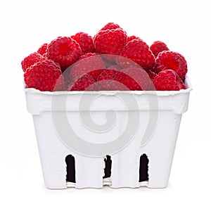 Raspberries in a white paper carton isolated on white