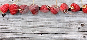 Raspberries on a wooden background. Banner size with copy space. Top view of ripe berries. Flat lay.
