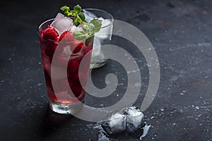 Raspberry alcoholic cocktail with liqueur, vodka, ice and mint on a dark background. Raspberry Mojito. Refreshing cool drink,