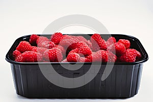 Raspberry in black container isolated on white background
