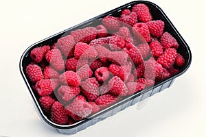 Raspberry in black container isolated on white background
