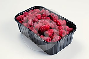 Raspberry in black container isolated on white background
