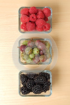 Raspberry, blackberry and gooseberry in glass cups