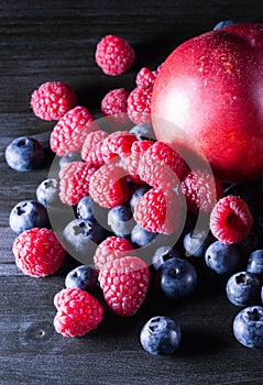 Raspberry, blueberry and nectarine on dark wooden background, st