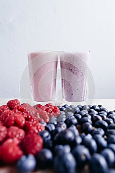 rapsberry and blueberry smoothie with fresh berries on wood table