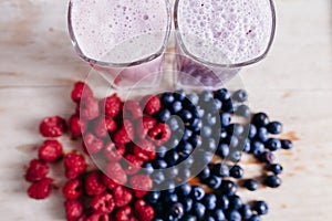 rapsberry and blueberry smoothie with fresh berries on wood table