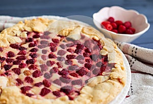 Raspberry cake on blue table, side view, close up