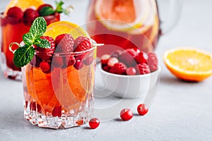 Raspberry Cranberry Sangria Punch or Mojito in glass with orange slices and mint