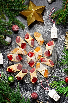 Raspberry filled bow tie cookies kolaczki on a Christmas rustic background photo