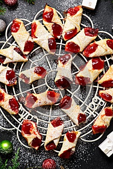 Raspberry filled bow tie cookies kolaczki on a Christmas rustic background photo