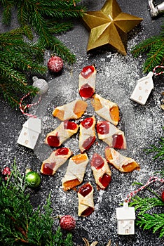 Raspberry filled bow tie cookies kolaczki on a Christmas rustic background photo