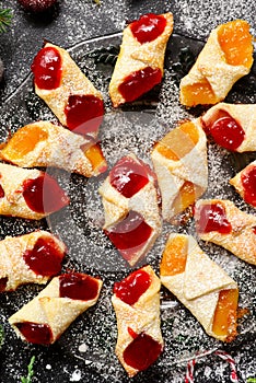 Raspberry filled bow tie cookies kolaczki on a Christmas rustic background photo