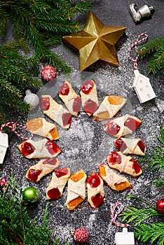 Raspberry filled bow tie cookies kolaczki on a Christmas rustic background photo
