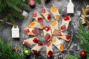 Raspberry filled bow tie cookies kolaczki on a Christmas rustic background photo