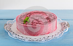 Raspberry ice cream cake on rustic blue wood