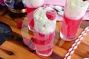 Raspberry Italian Cream Sodas Made Topped with Whipped Cream and Frozen Raspberries