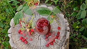 Raspberry jam in a jar in the garden. Selective focus.