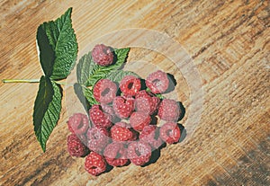 Raspberry with leaves on a wooden table