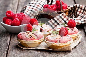 Raspberry macaroon tarts on wooden table