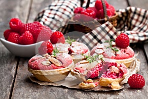 Raspberry macaroon tarts on wooden table