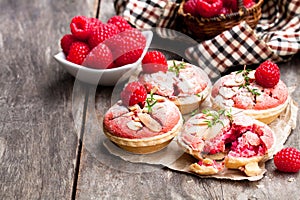 Raspberry macaroon tarts on wooden table