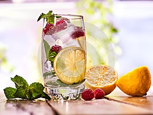 Raspberry mojito with cubes ice glass. Outdoor.