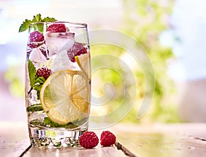 Raspberry mojito with cubes ice glass. Outdoor.