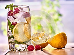 Raspberry mojito with cubes lemon ice glass. Outdoor.