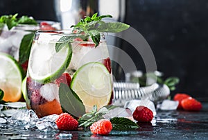 Raspberry Mojito Lemonade with lime and fresh mint in glass on gray background. Summer refreshing cocktail