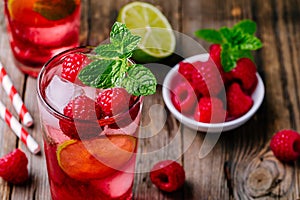 Raspberry Mojito Lemonade with lime and fresh mint in glass on wooden background