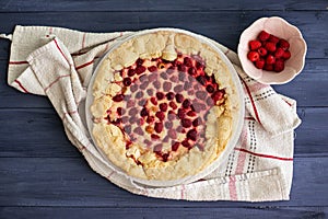 Raspberry pie or galette on blue wooden table, top view