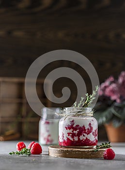 Raspberry smoothie, milkshake in a glass jar on a dark wooden background. Natural summer detox drink. Healthy eating concept