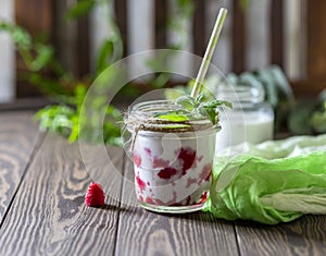 Raspberry smoothie, milkshake in a glass jar on a dark wooden background. Yogurt cocktail. Natural summer detox drink